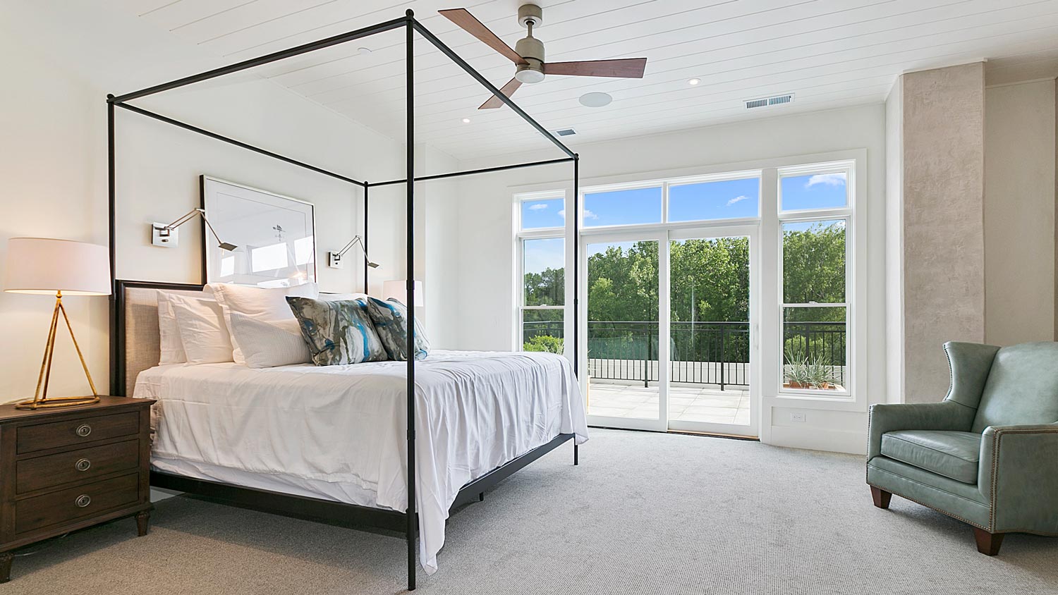 A carpeted bedroom with a large canopy bed