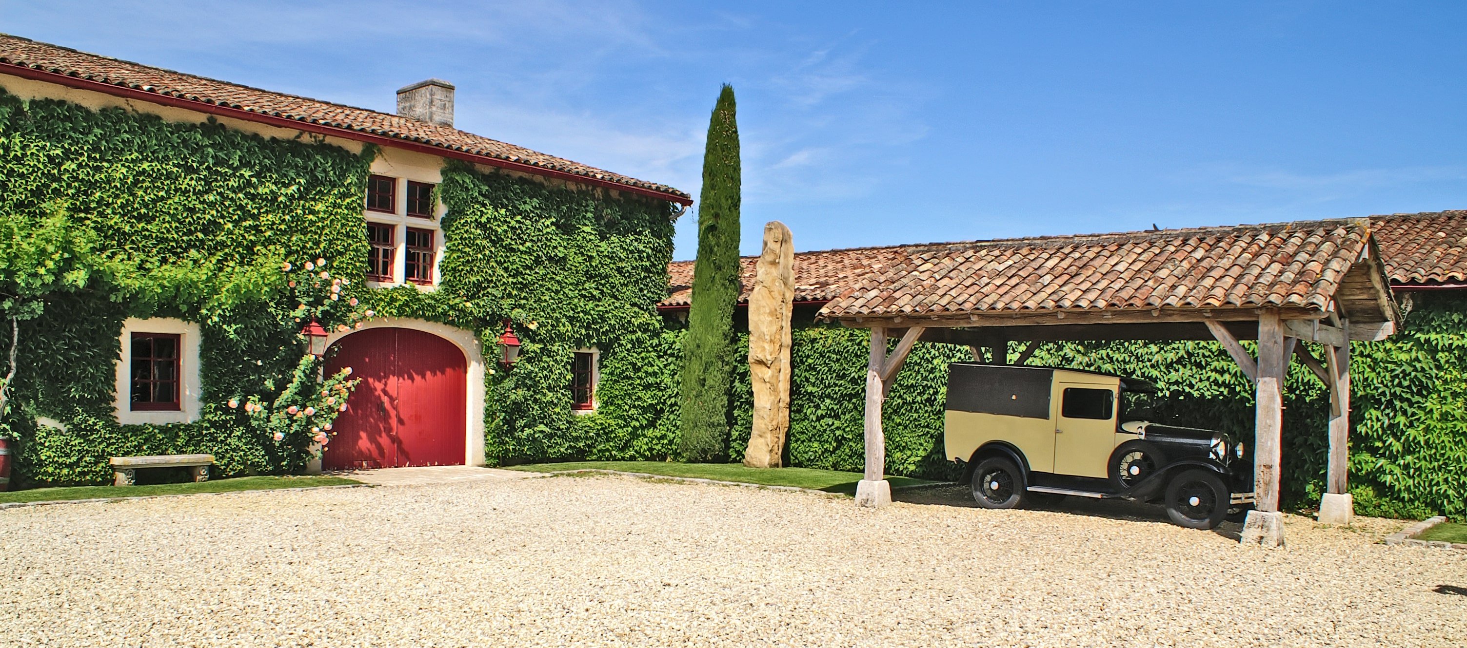 Freestanding carport covering vintage car outside of home