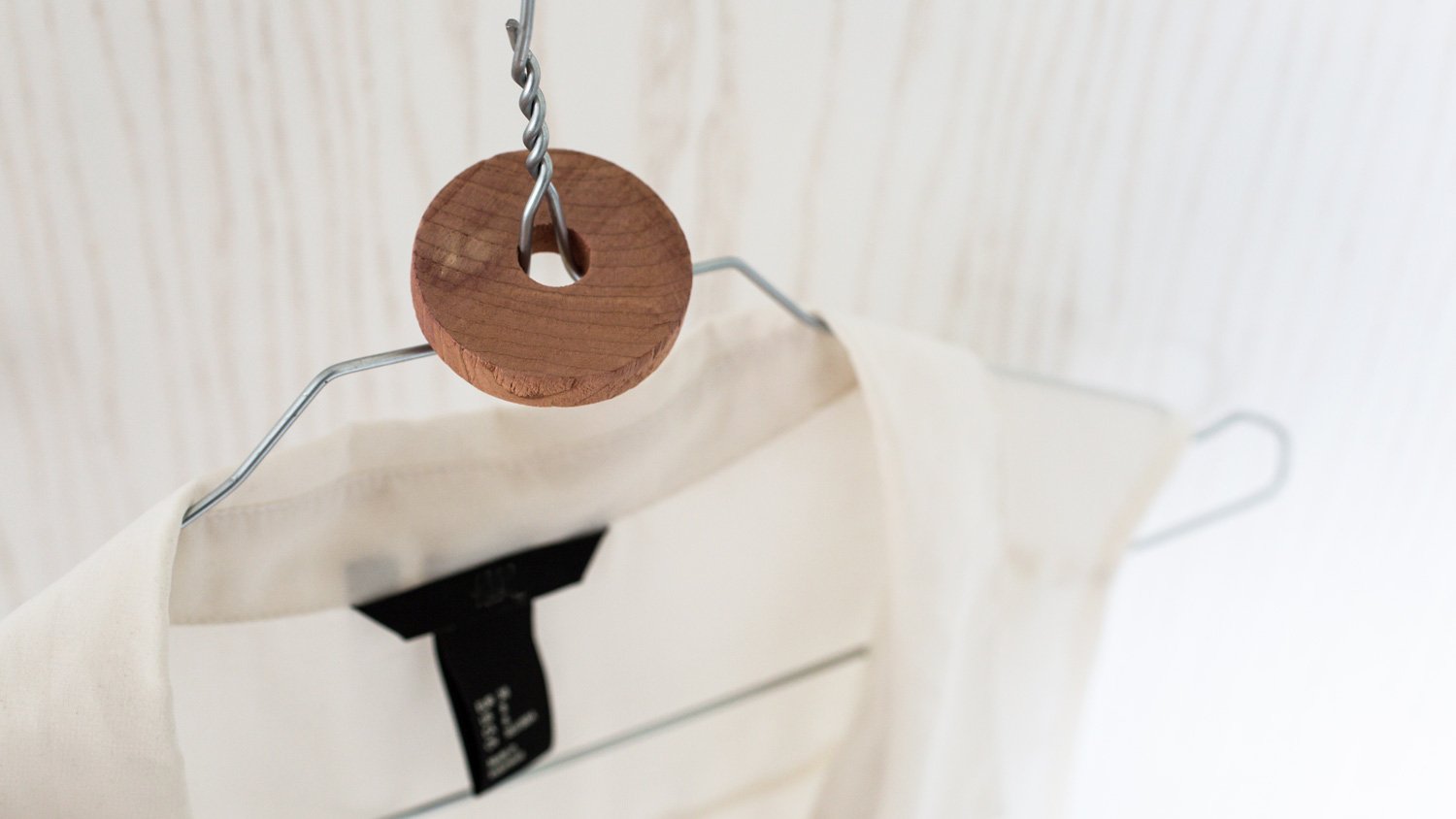 A cedar wood disk on a clothes hanger used as a moth repellent