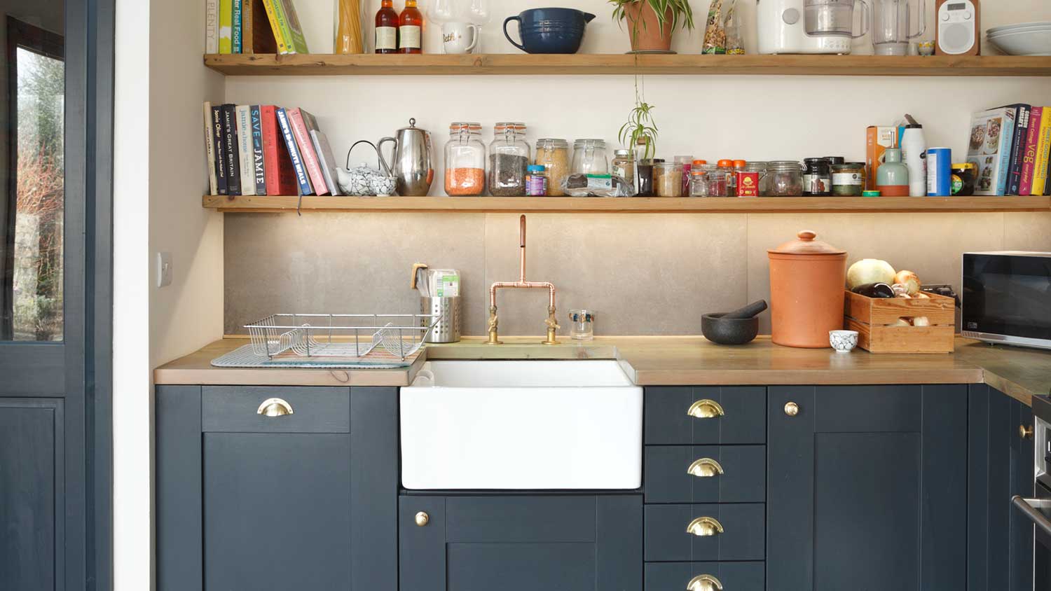 Ceramic sink installed in a kitchen with blue cabinets