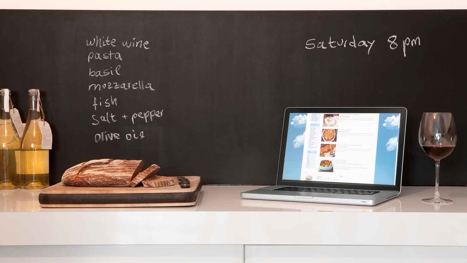 grocery list written on a chalkboard backsplash