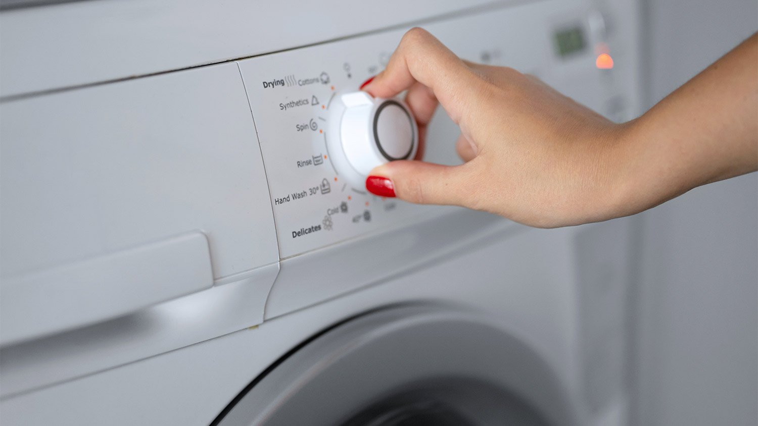 A person adjusting the settings on a dryer