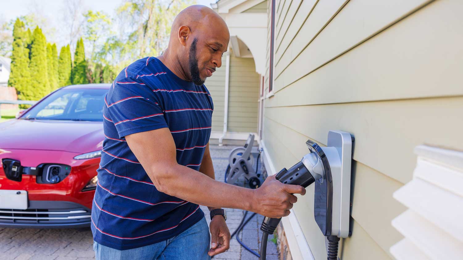 man charging his car in driveway