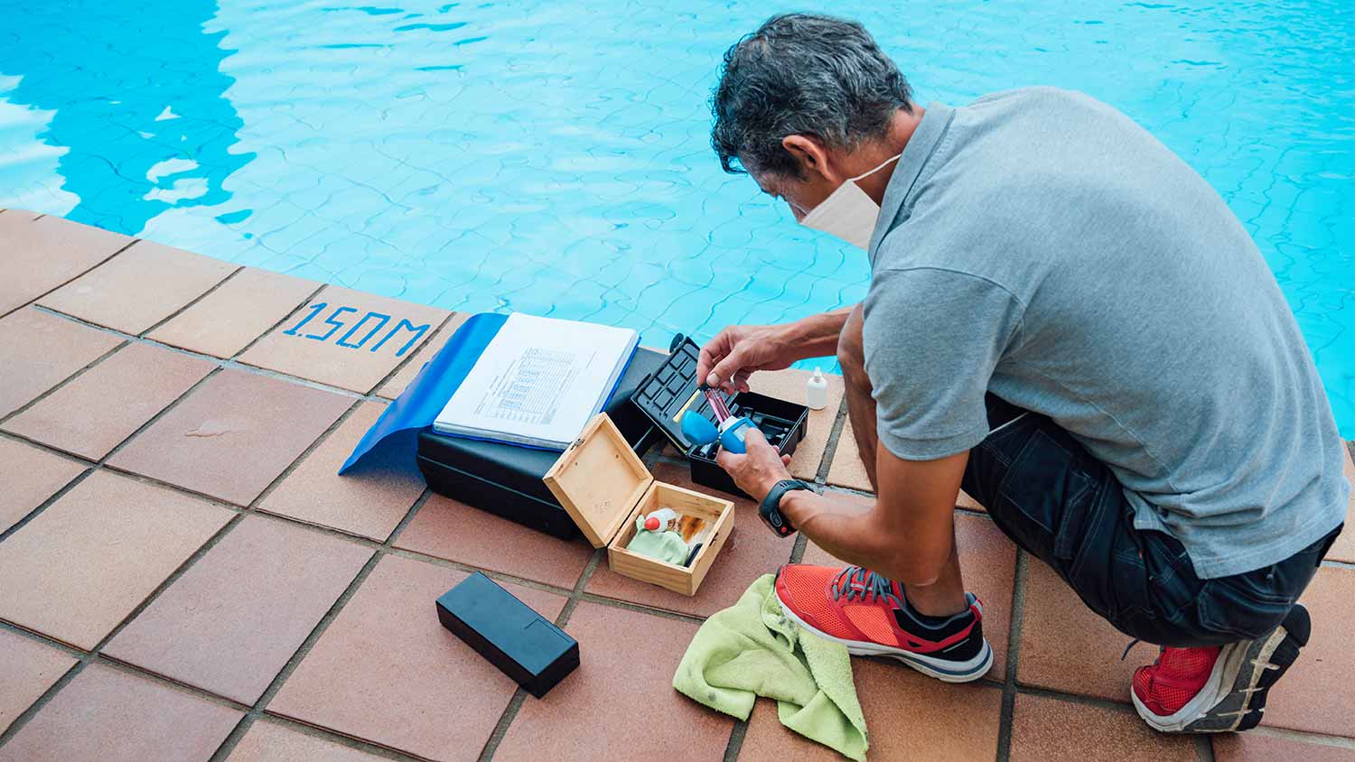 man checking ph level in pool
