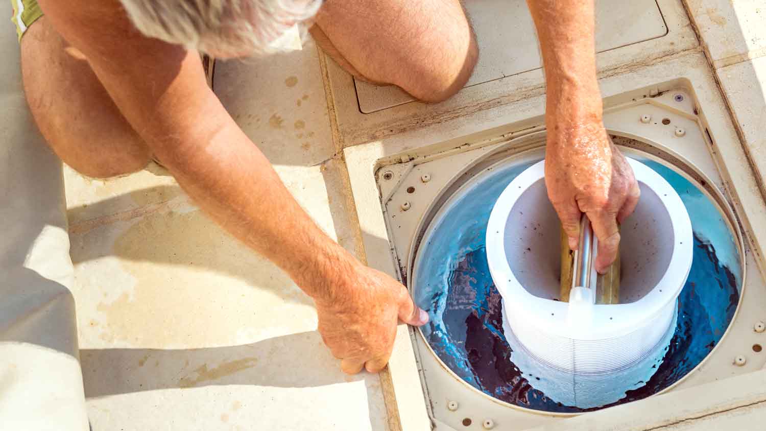 Man checking swimming pool filter