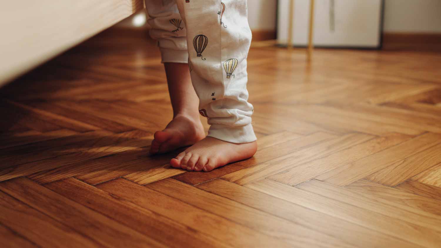 Child feet on wooden floor 