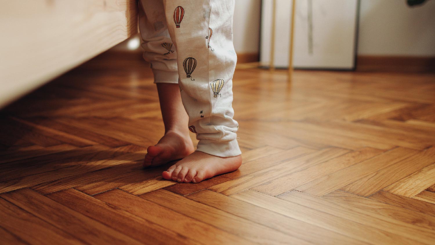 A child’s legs on a wooden floor