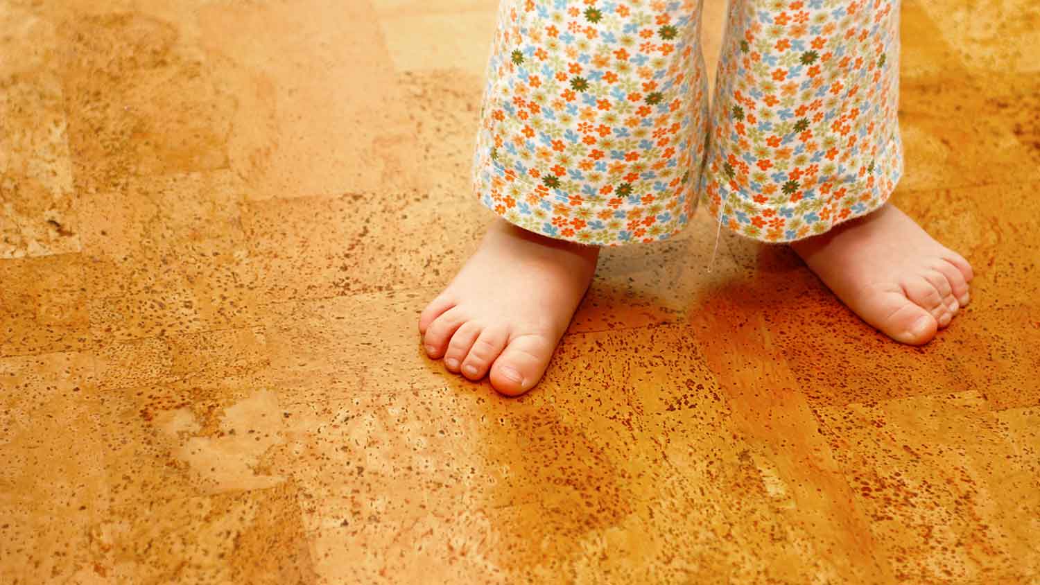 Barefoot child standing on a cork flooring