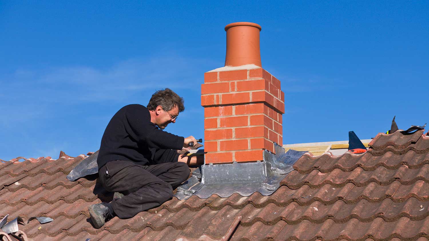 Worker installing new chimney flashing