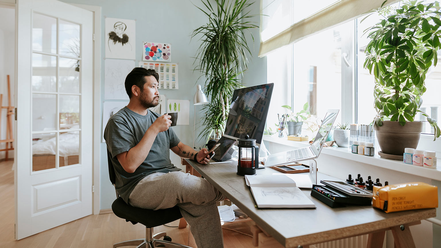 igital artist contemplates during coffee break in his home office