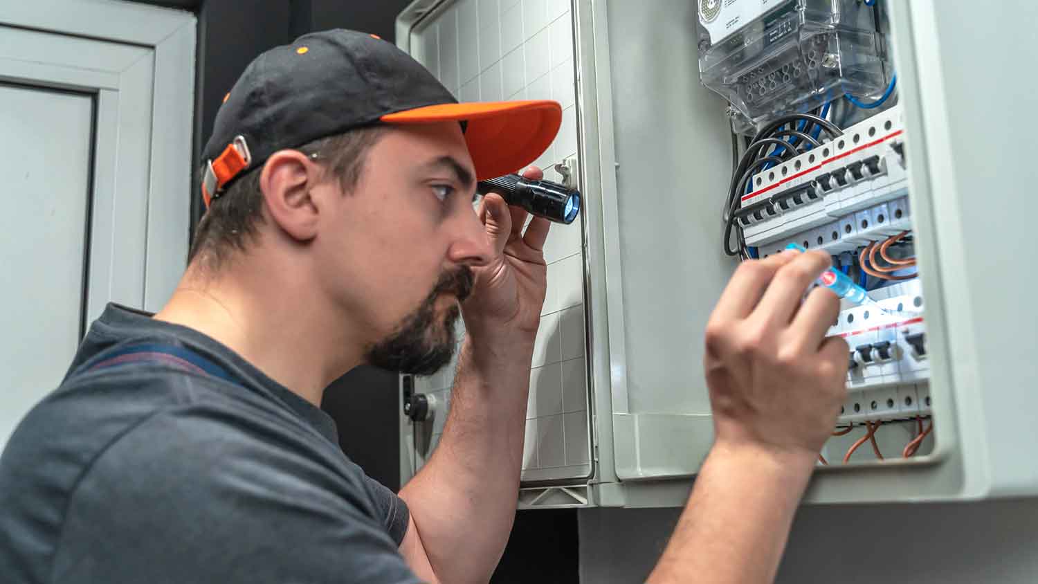 Electrician repairs circuit breaker in the breaker box