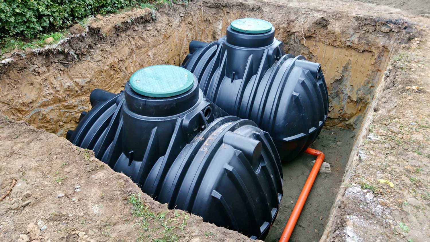 Two plastic underground storage tanks placed below ground for harvesting a rainwater.