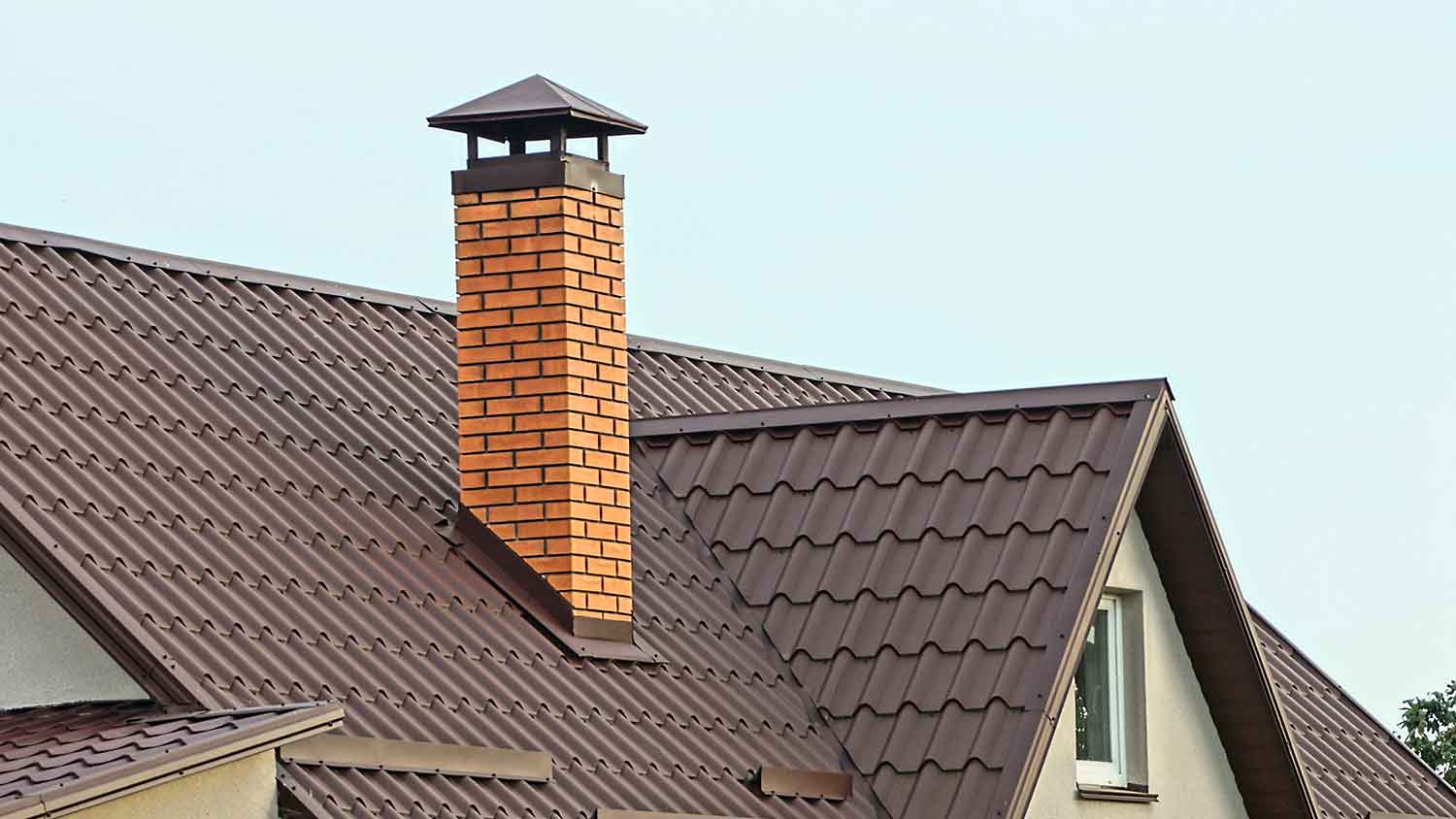 Brick chimney on a brown metal roof
