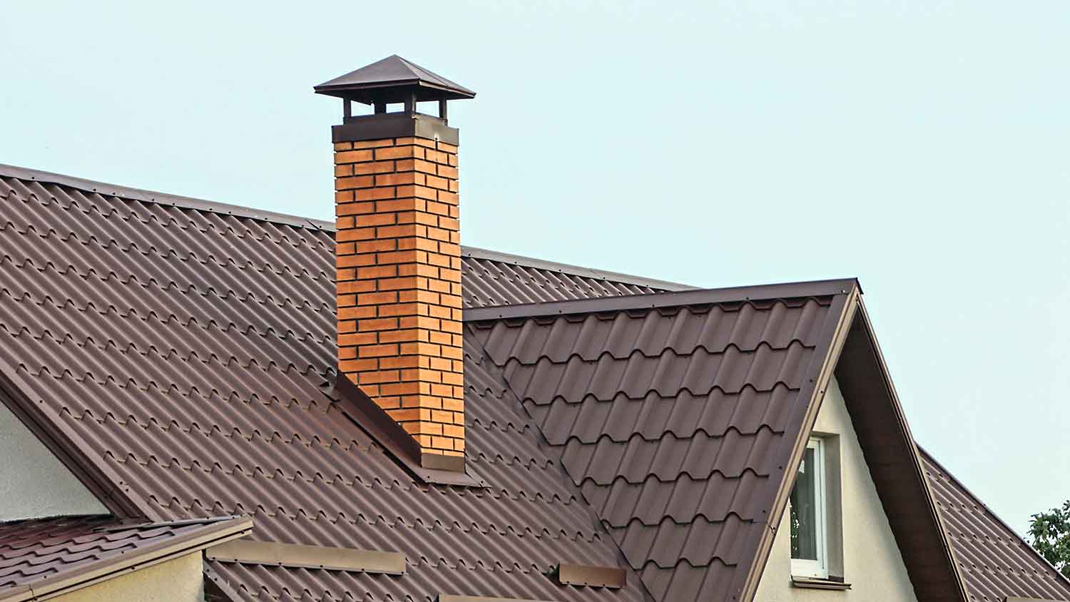 Brick chimney on a brown metal roof 