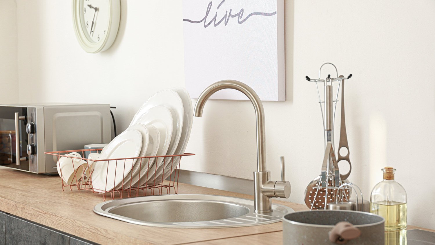 Rack of clean dish-ware by the kitchen sink