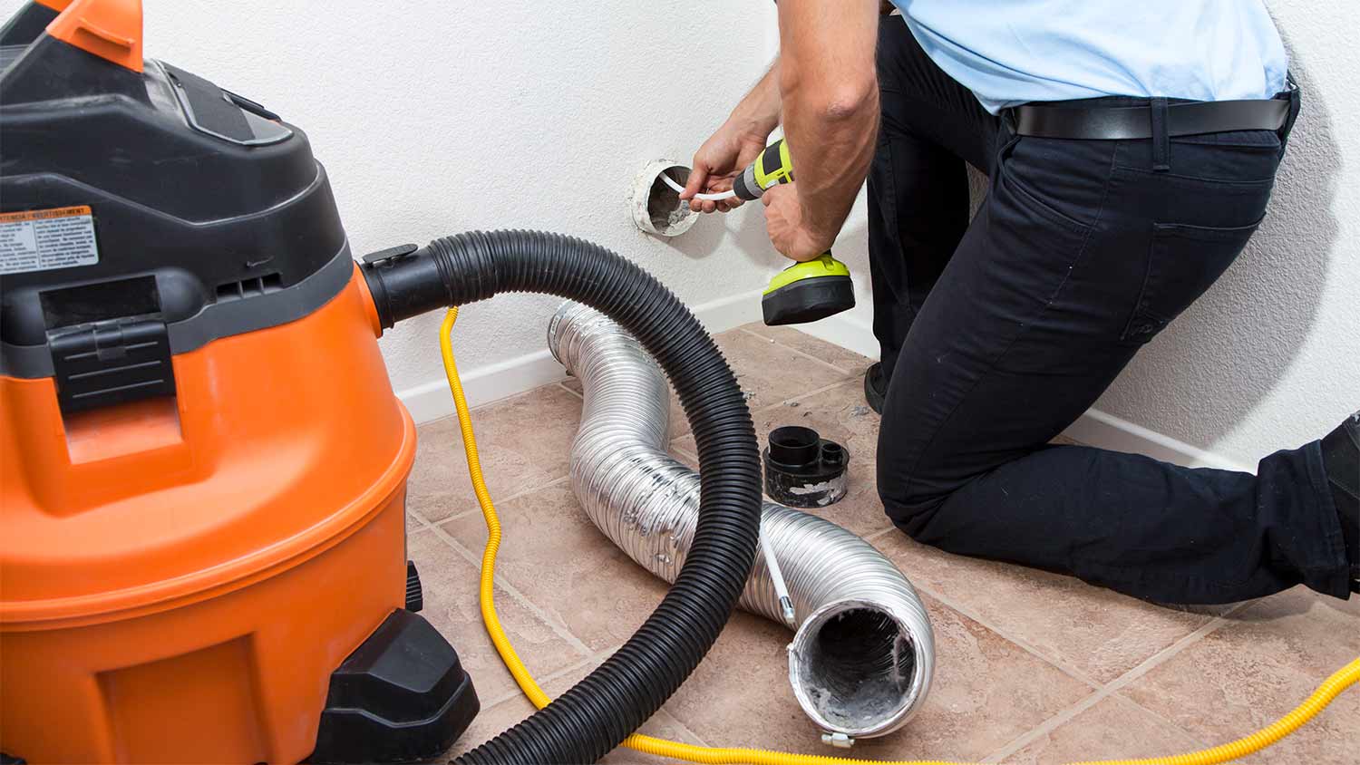 A technician cleaning a dryer vent