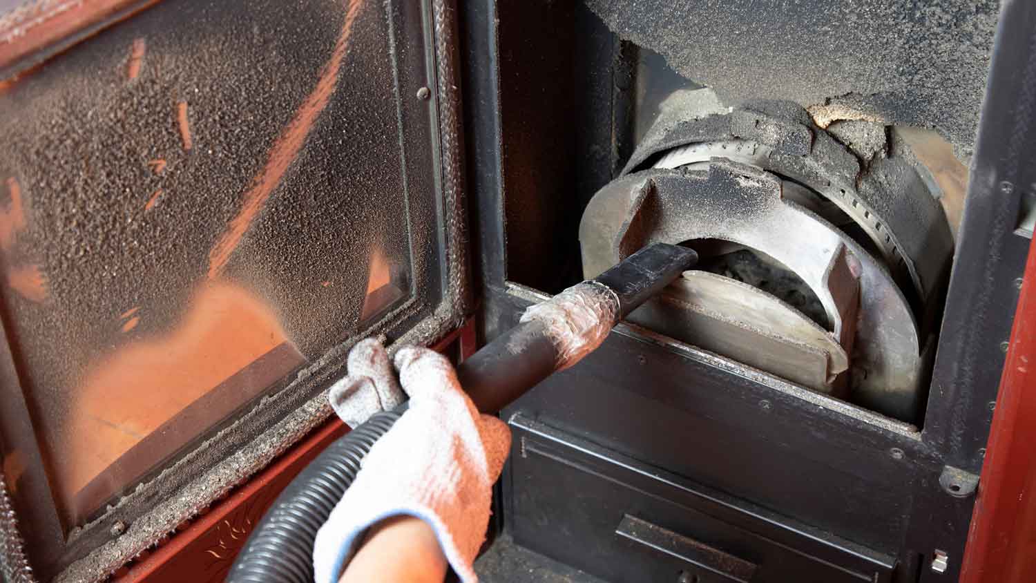 person cleaning pellet stove 