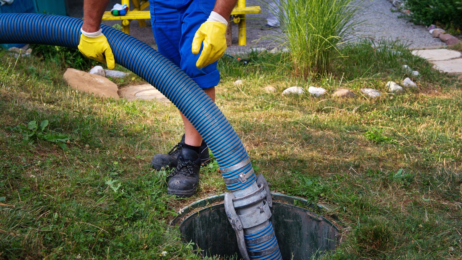 worker emptying septic tank