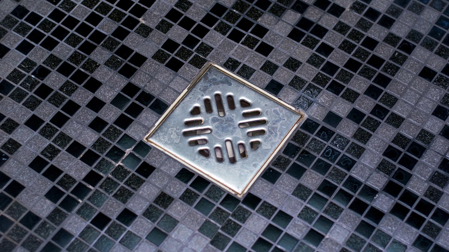  A clean shower drain in a dark gray bathroom