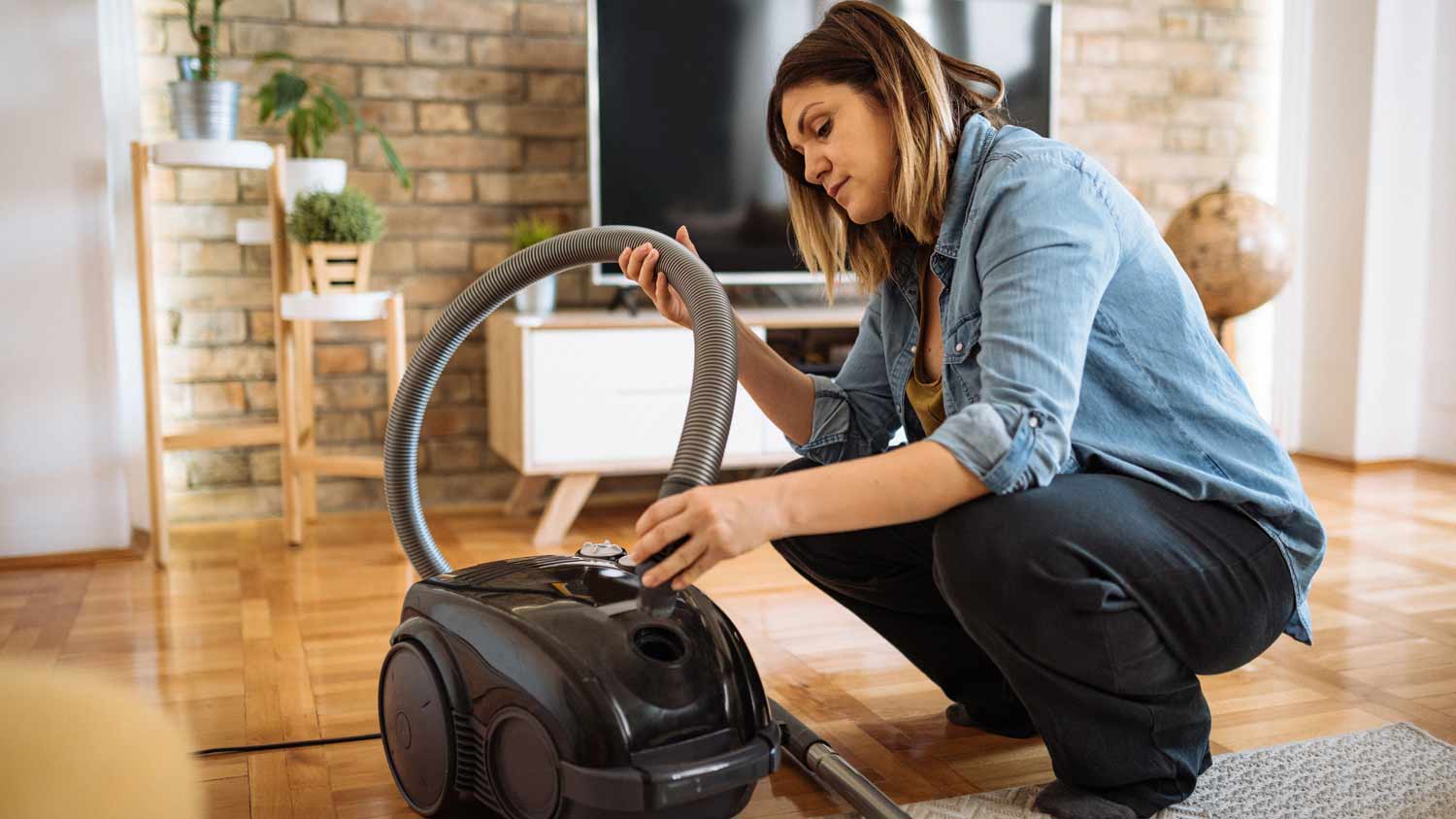 woman cleaning out vacuum hose