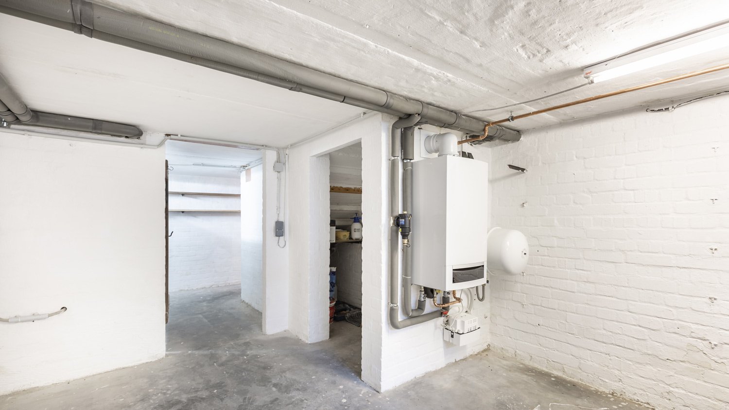 Clean Basement with white paint and silver pipes