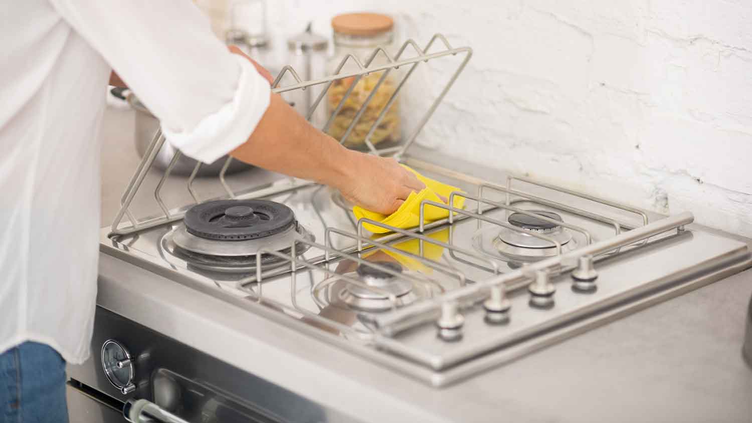 Woman cleaning stainless steel stove