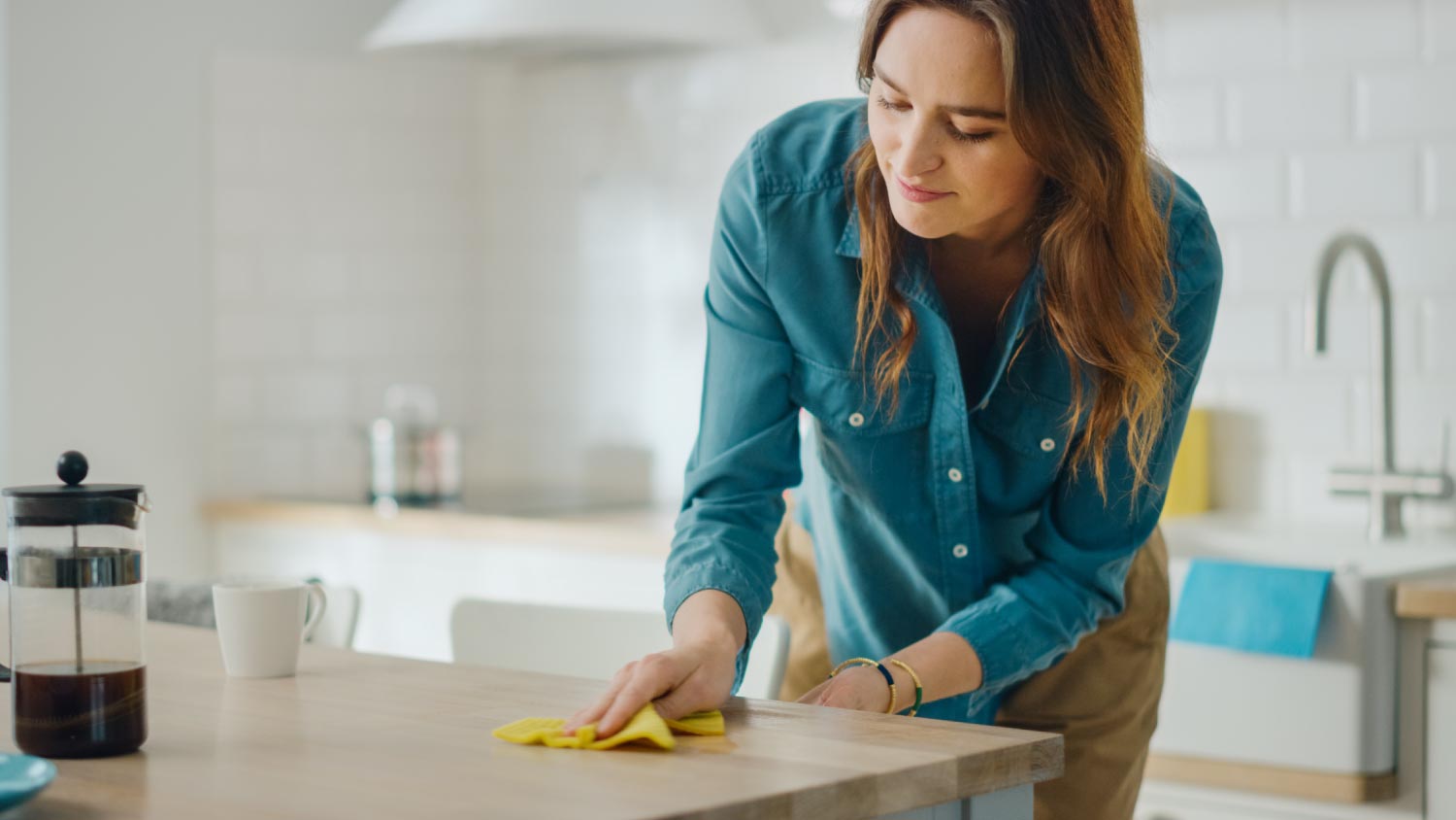 Woman cleaning spilled coffee on the kitchen counter