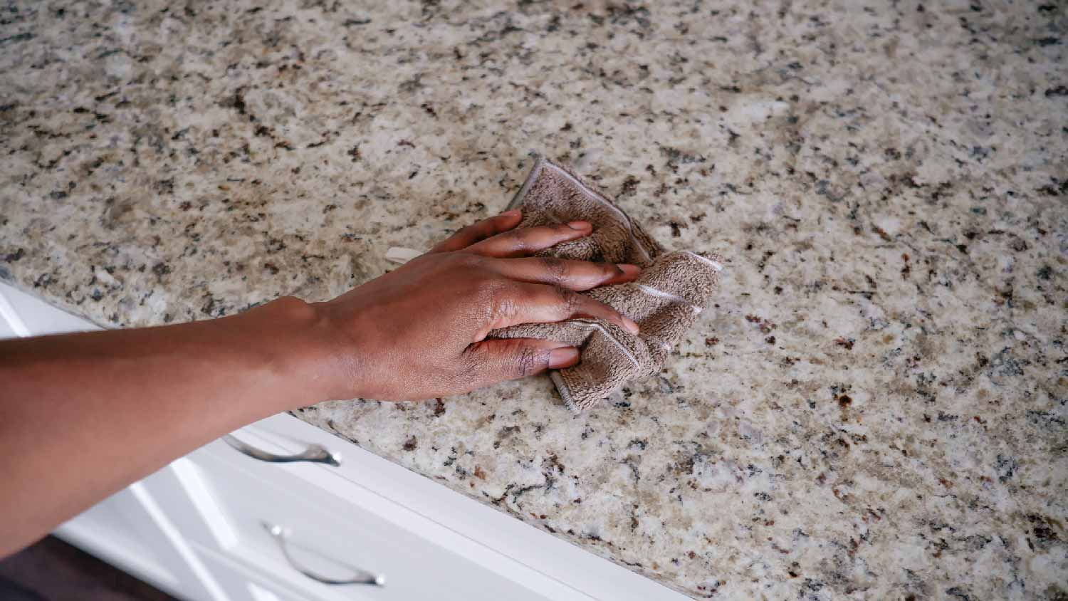 A person cleaning a quartzite countertop