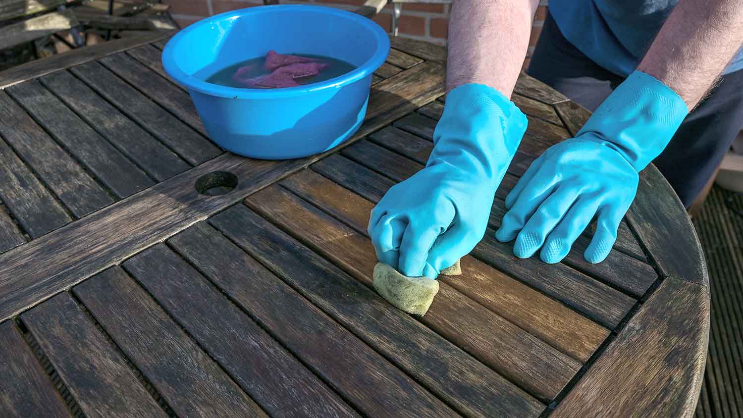 Man using cloth to clean wooden table