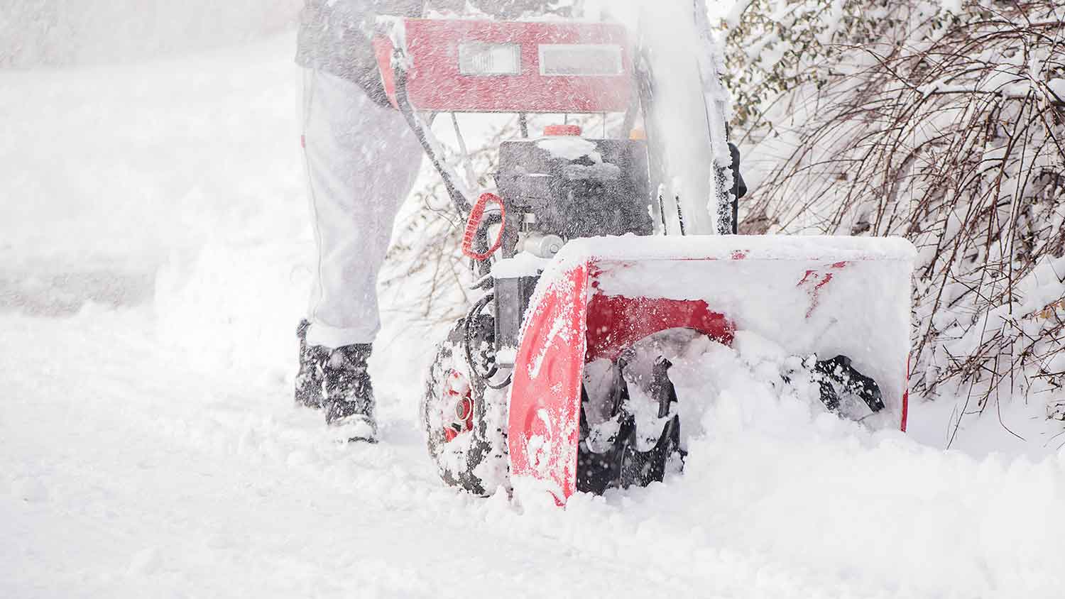 Homeowner clearing snow in the driveway with snow blower