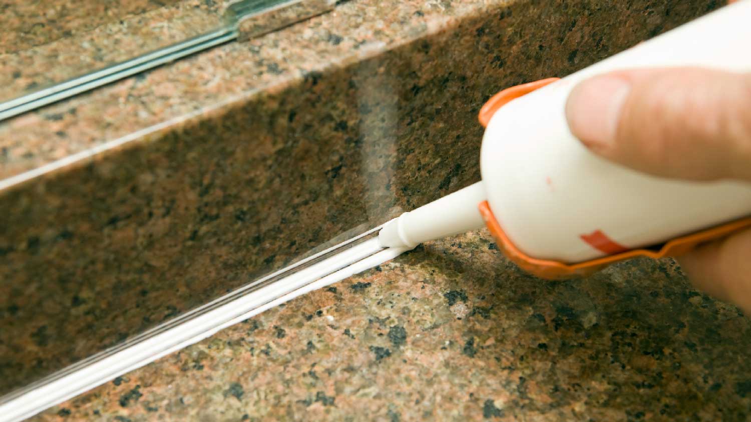 Close-up of a person applying caulk