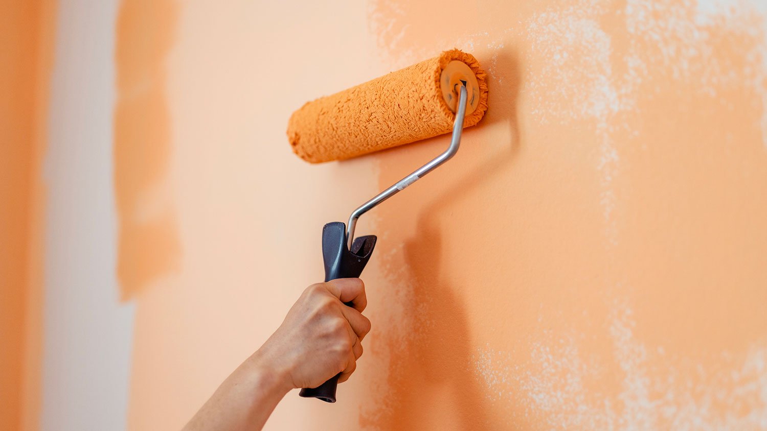 Close-up of painting a wall with a roller