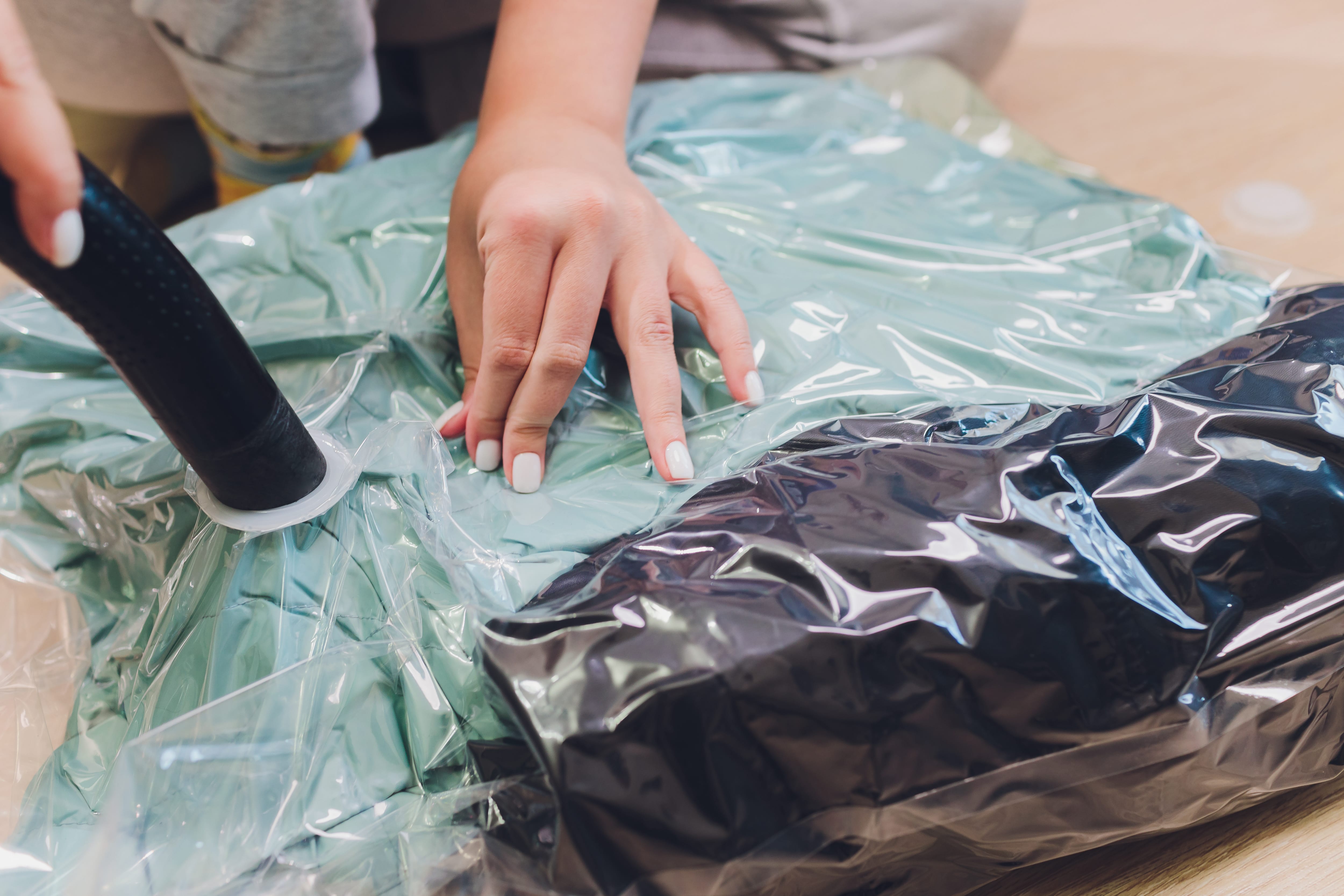 A woman storing clothes in a vacuum sealed bag