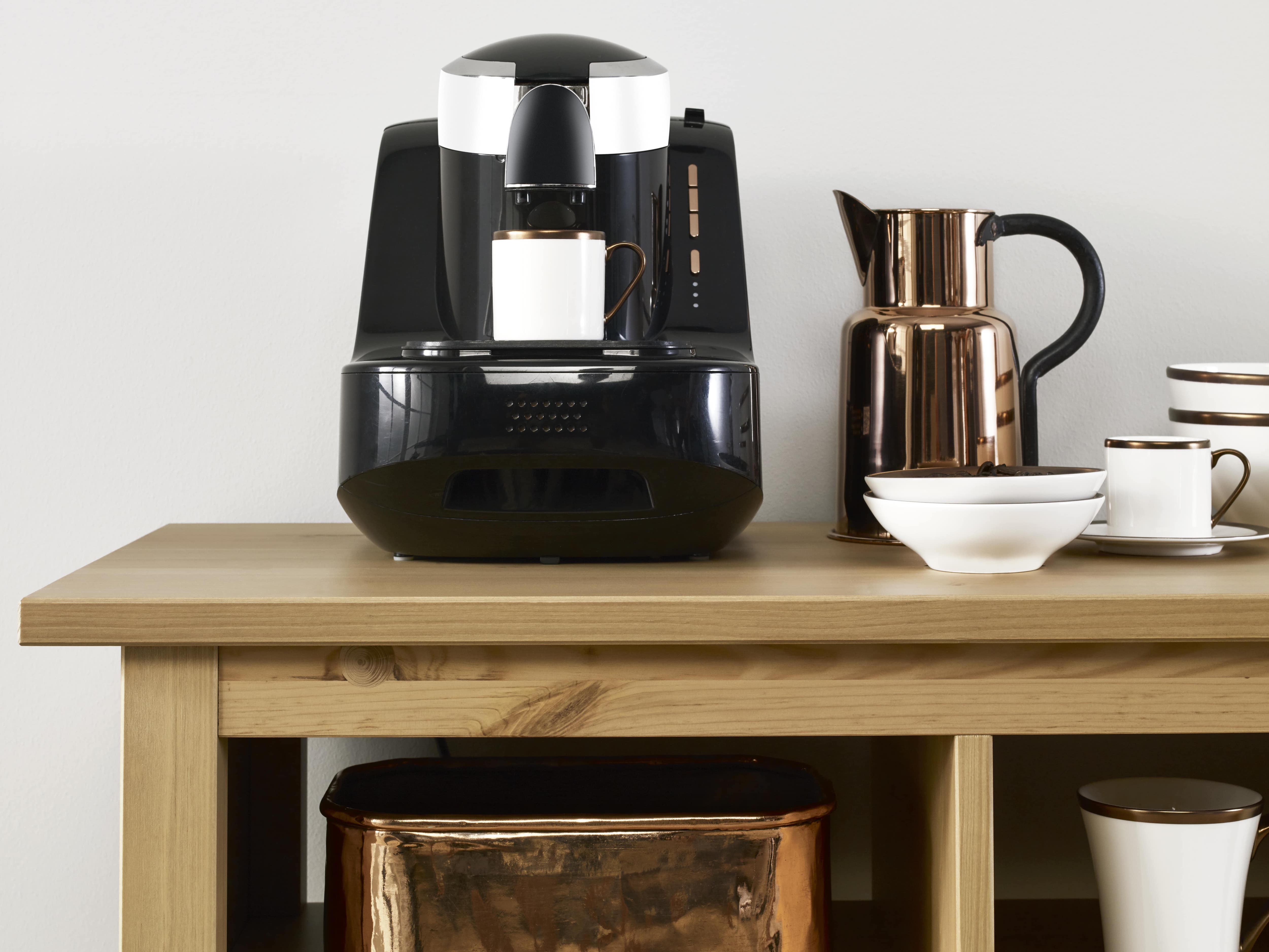 Coffee maker and mugs on wooden shelf