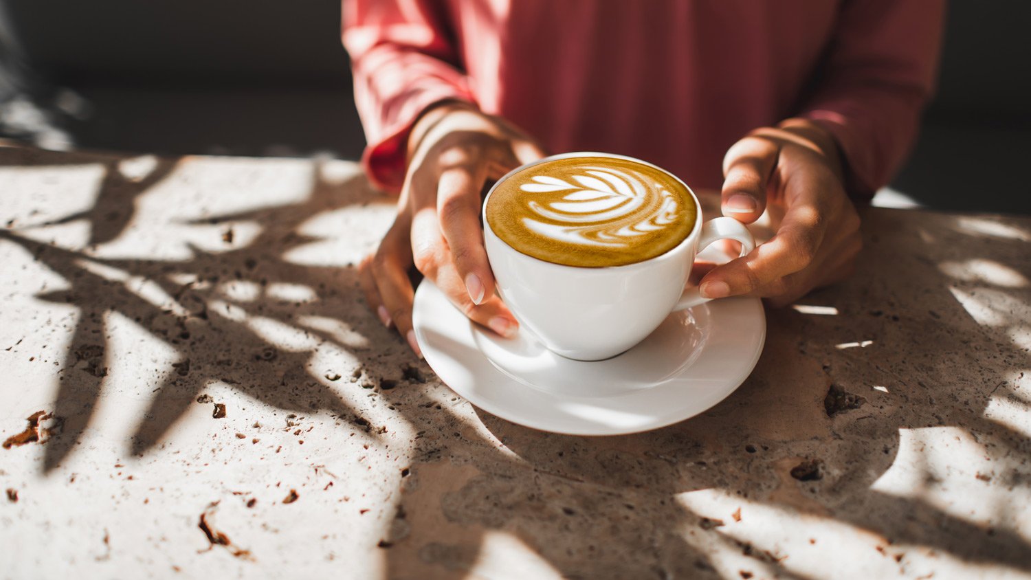 Woman hands holding cup of fresh cappuccino