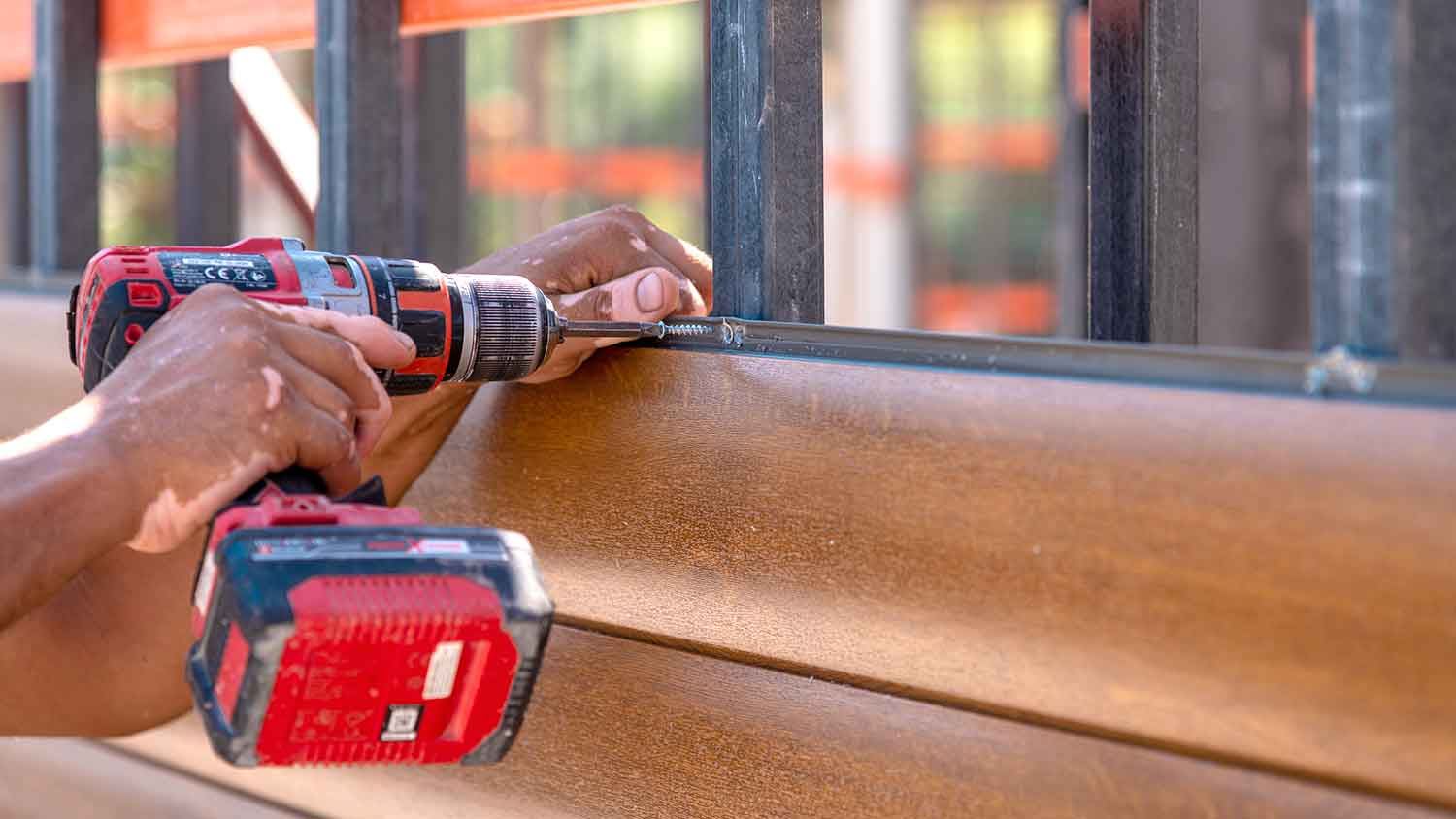 Worker installing composite siding on the house 