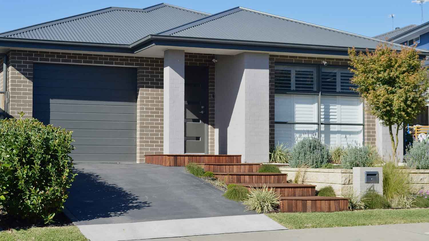 A concrete sidewalk in front of a house