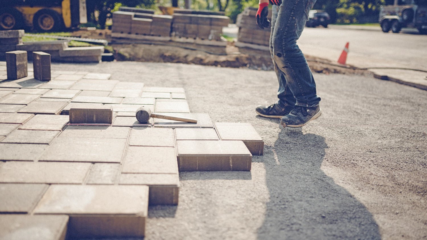 Young man installing paving stones for a new driveway