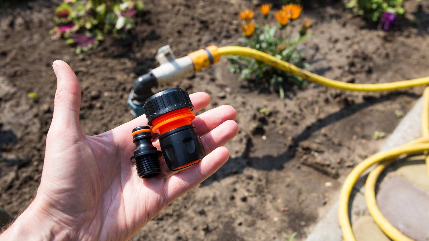 man holding connector for water hose