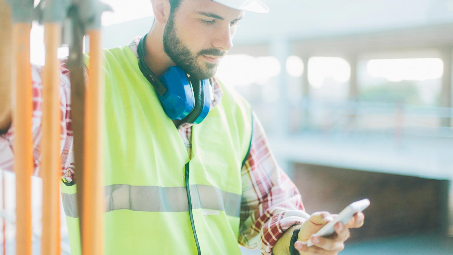 A constructor checking the weather on his phone