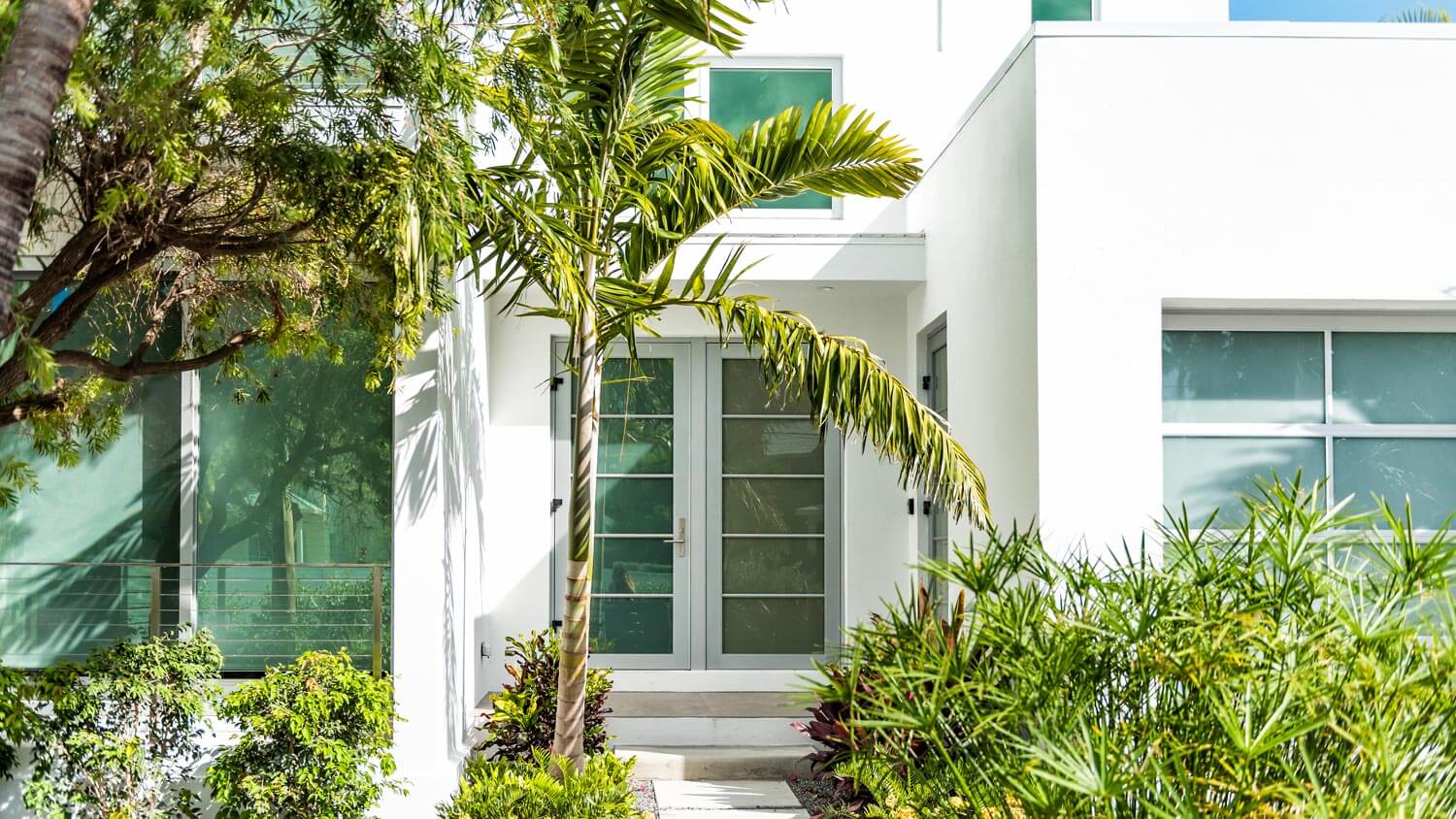 A contemporary house with glass front door and windows