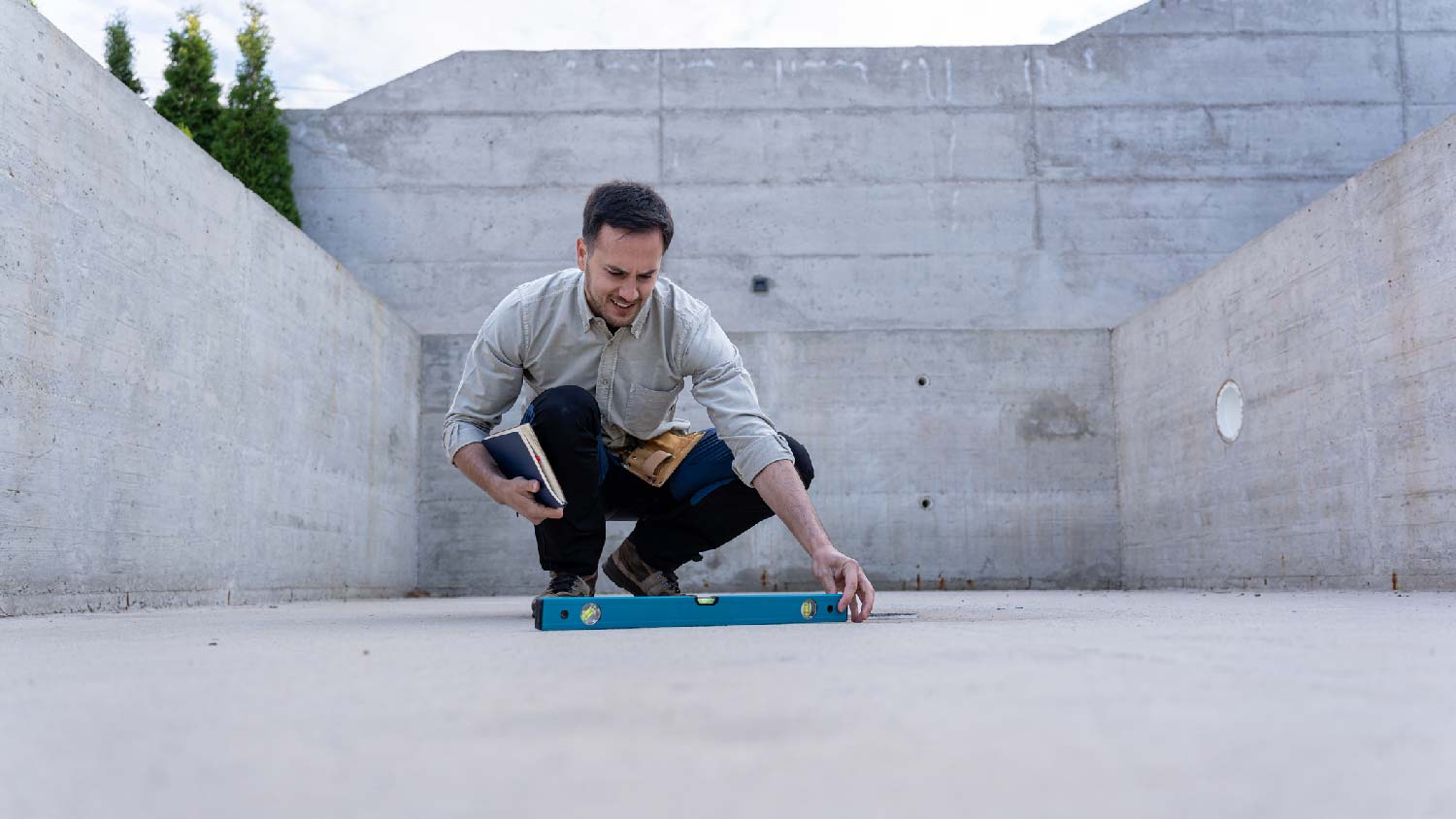 A contractor inspecting the level of a concrete surface 