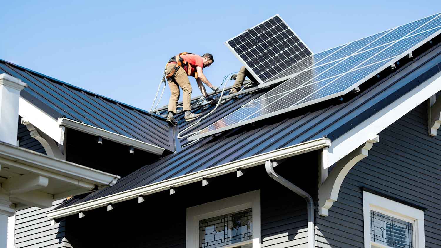 Contractor installing solar panels on the roof of a house