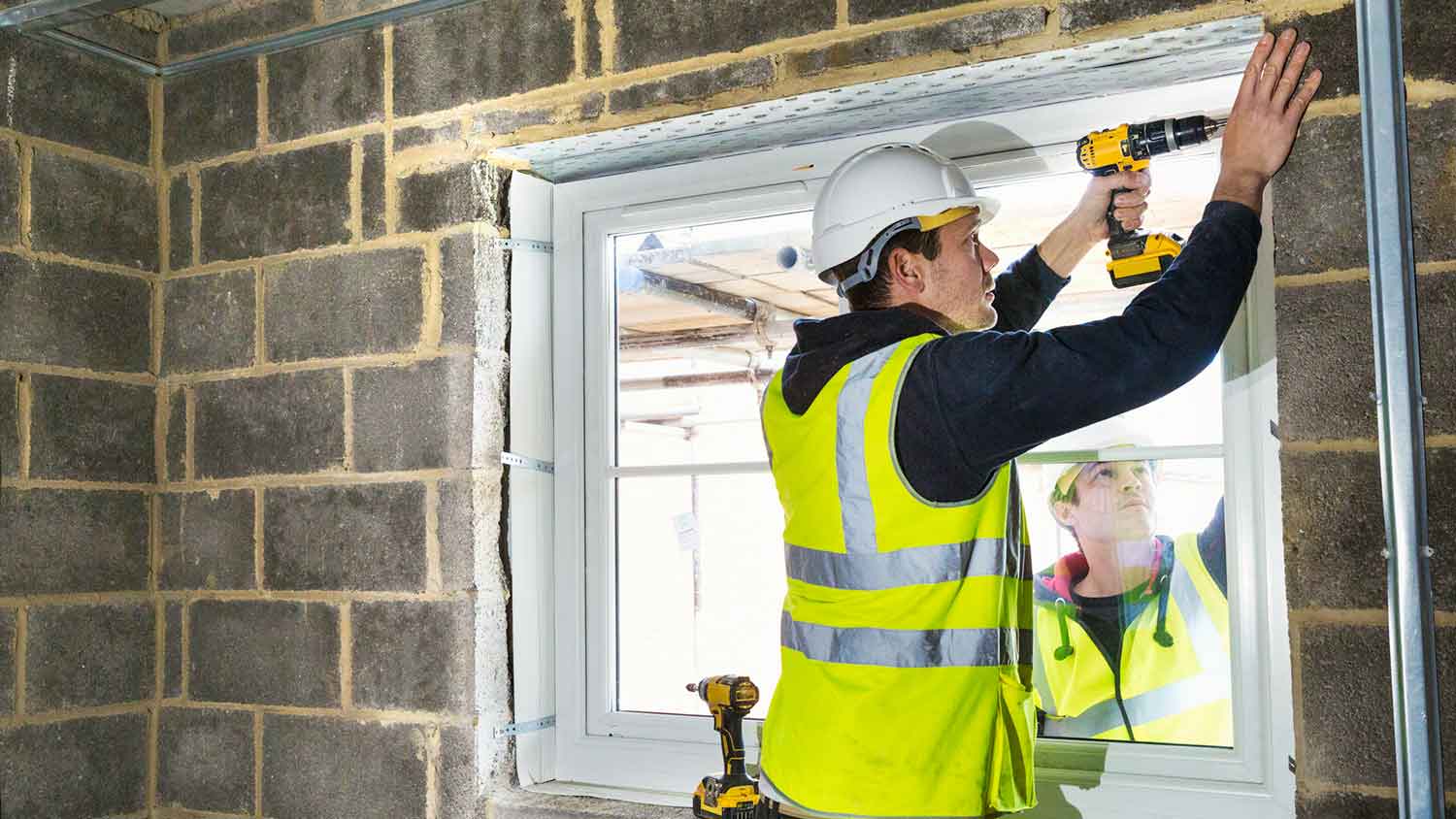 Contractor installing window in the basement 