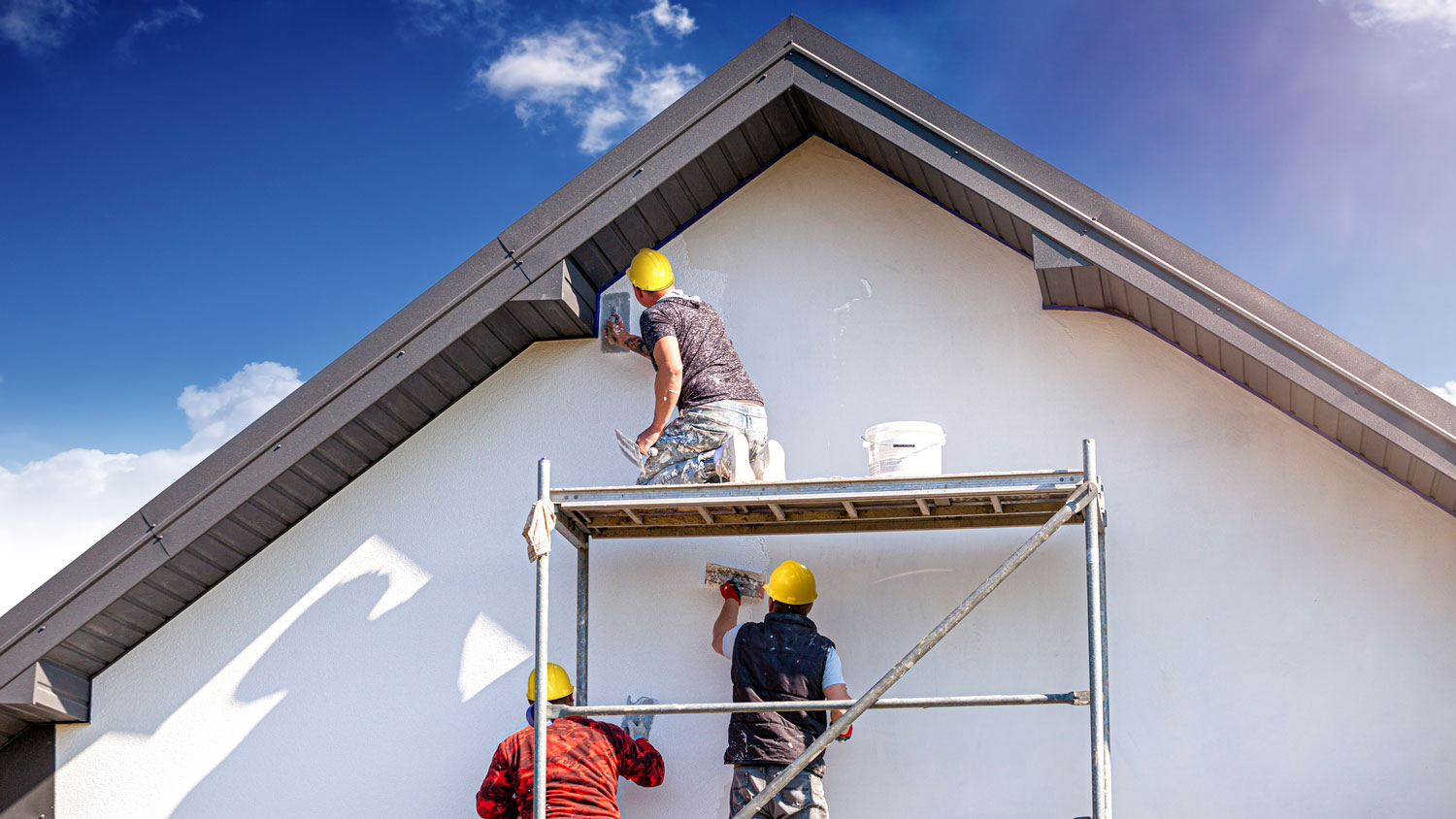 Contractors painting the exterior of a house