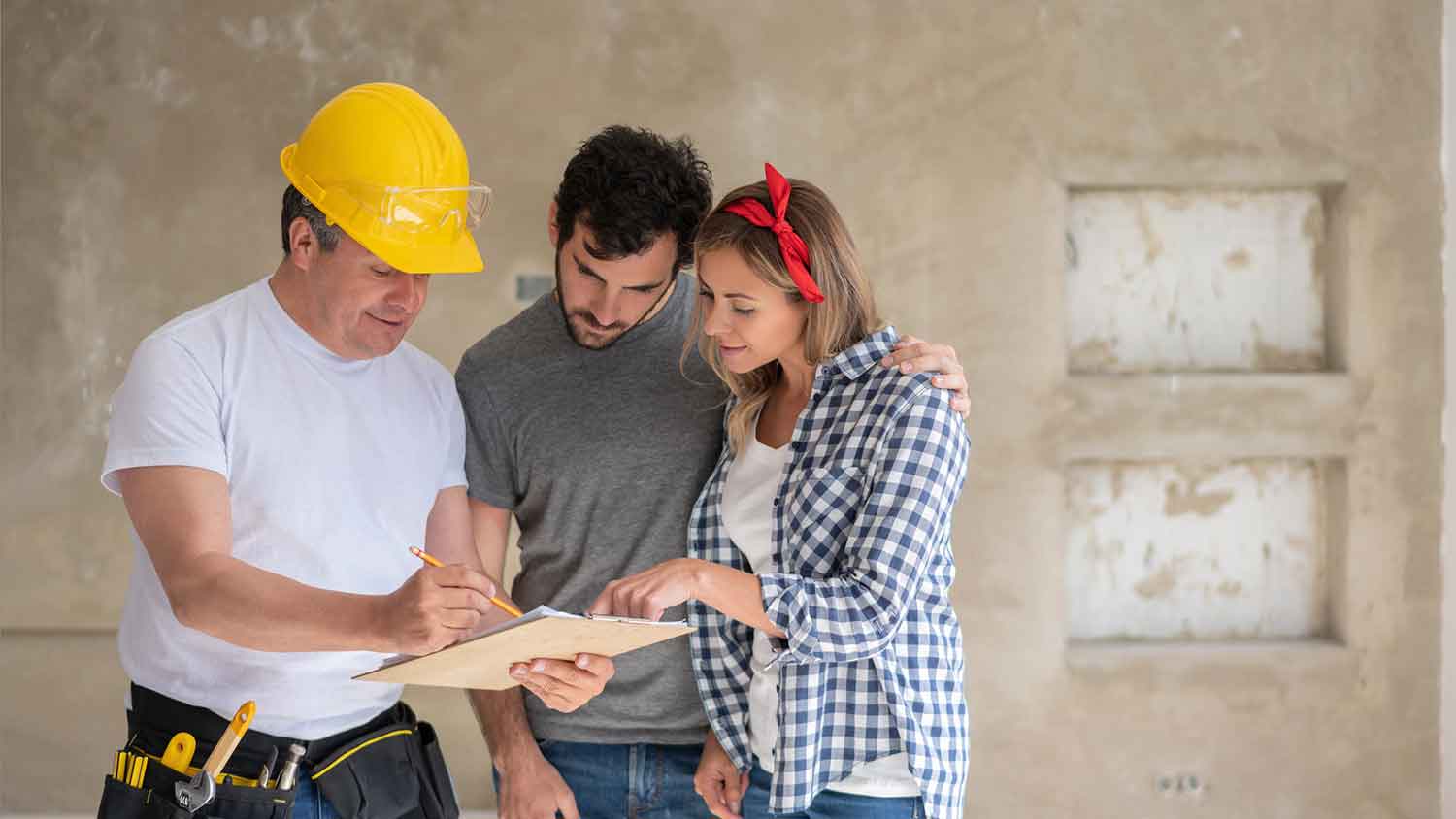 Contractor holding a clipboard and talking with a couple