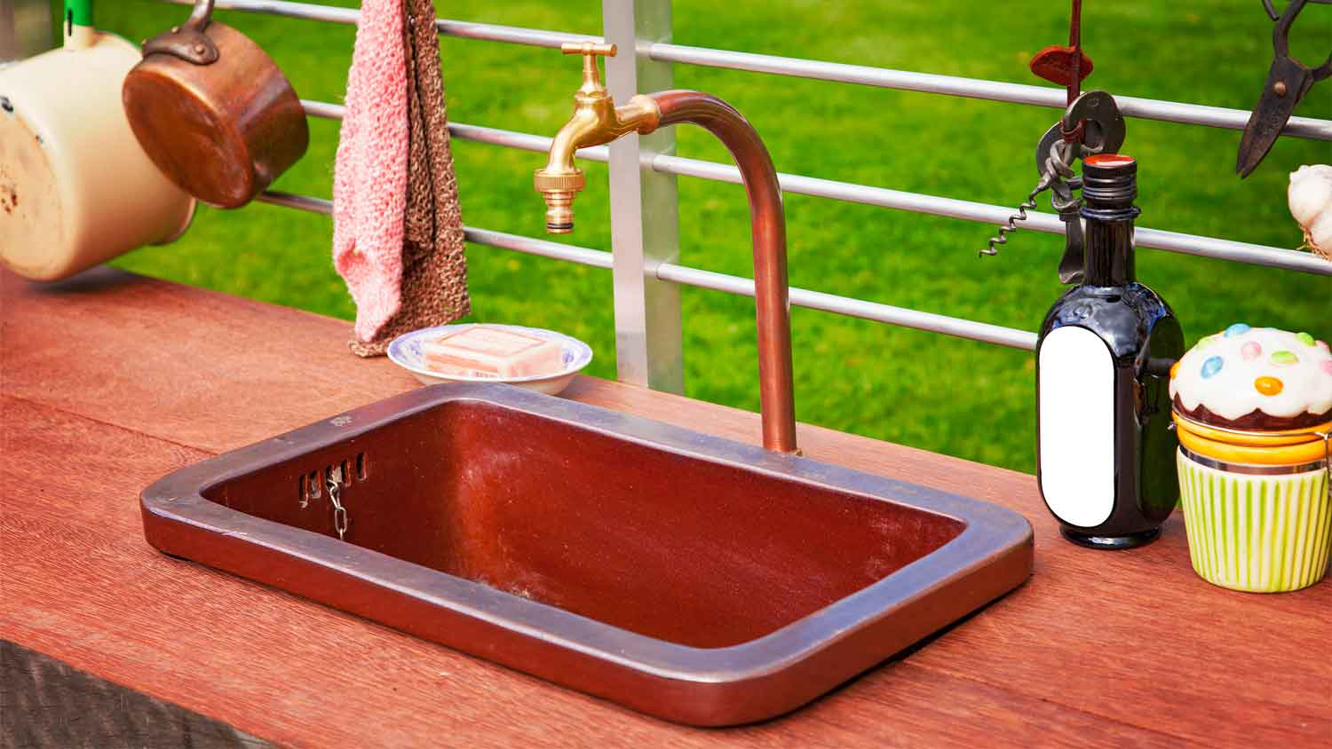 A copper sink in an outdoor rustic kitchen