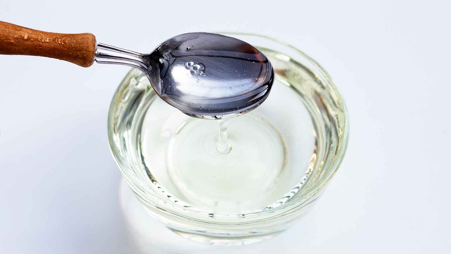 Corn syrup and a spoon in a small bowl