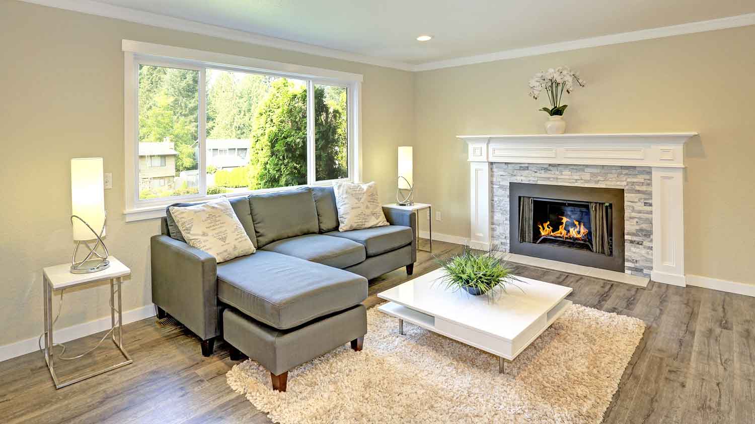 Living room corner with crown molding and a fireplace
