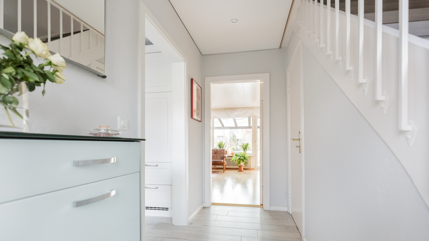 A house’s bright corridor with a room in the background